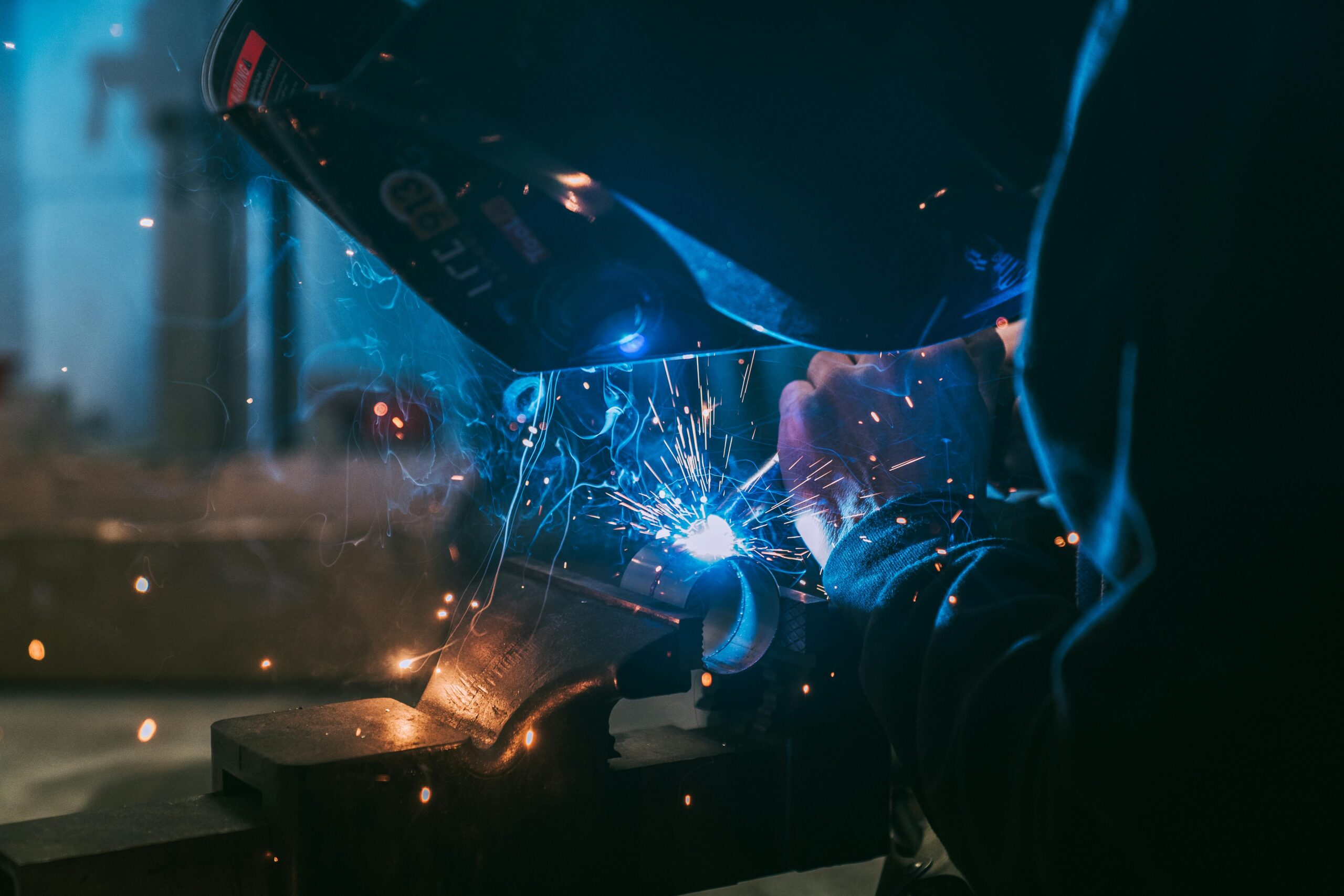 Close-up of a welder working with sparks flying, showcasing industrial craft in Paris.